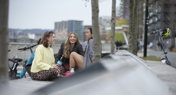 glade unge kvinder taler i byparken