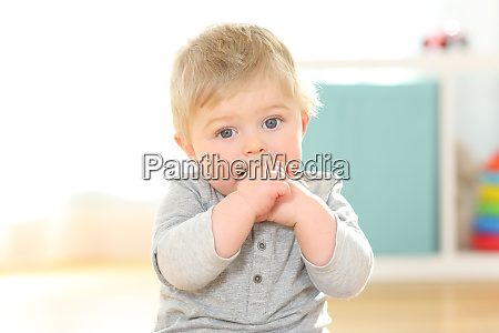 Portræt af et barn der bider fingrene og kigger på - Stockphoto #26549918 | Billedbureau