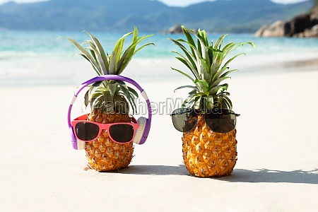 Kontoret virksomhed verden Ananas med hovedtelefon og solbriller på sand på - Stockphoto #26938638 |  PantherMedia Billedbureau